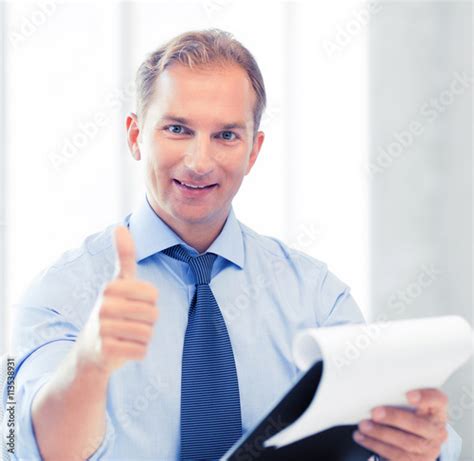 Businessman With Papers Showing Thumbs Up Stock Photo And Royalty