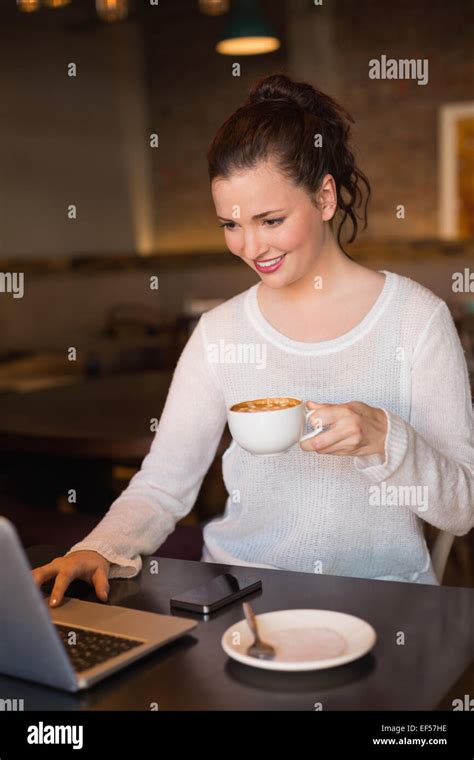 Pretty Brunette Having Coffee Using Laptop Stock Photo Alamy