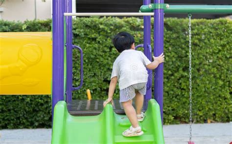 Child Playing On Outdoor Playground Kids Play On School Or