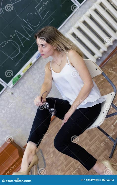 le jeune professeur blond strict s assied sur une chaise croisant ses jambes image stock image