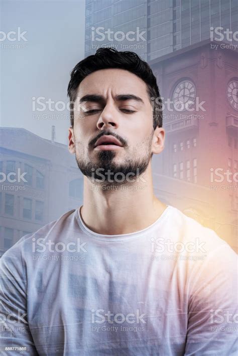 Serious Young Man Closing His Eyes While Remembering Important