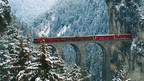 Red Train Of Albula Mountain Railway Passing Through A Scenic Winter