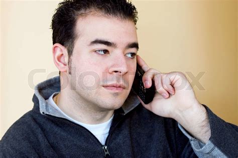 A Young Man Talking On His Cell Phone He Is Holding The Phone With His Right Hand But Listening