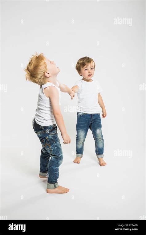 Studio Portrait Of Two Boys Holding Hands Stock Photo Alamy