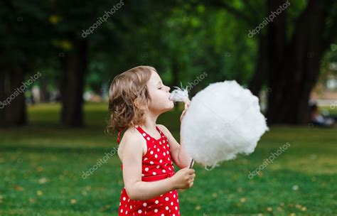 hermosa niña comiendo algodón de azúcar en el parque fotografía de stock © azaza 11810498