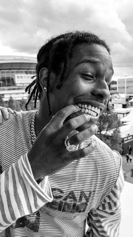 A Man With Dreadlocks Eating A Doughnut In Front Of A Stadium Area
