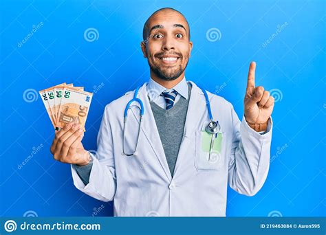 Hispanic Adult Doctor Man Wearing Medical Uniform Holding 50 Euros