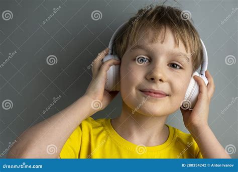 Happy Boy Listening To Music On Headphones Isolated On Gray Background