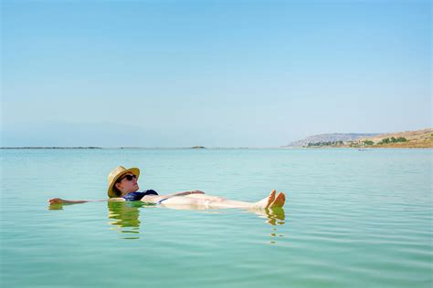 Woman Floating In Dead Sea Ein Bokek Photograph By Jason Langley