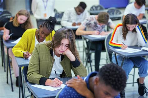 High School Girl Student Taking Exam At Desk In Classroom Stock Photo
