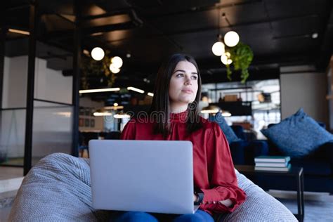 Caucasian Woman Working On Her Laptop In A Bean Bag Stock Image Image