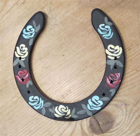 A Wooden Horseshoe With Painted Flowers On It