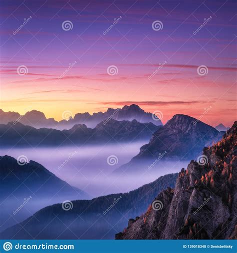 Mountains In Fog At Beautiful Sunset In Autumn In Dolomites Stock Photo