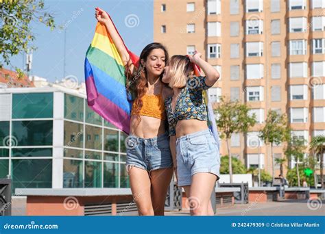 Young Lesbian Couple Smiling And Holding A Rainbow Flag Stock Image Image Of Girlfriends