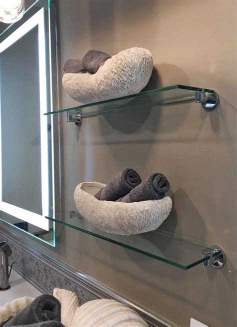 Two Glass Shelves With Towels On Them In Front Of A Mirror And Light Above It