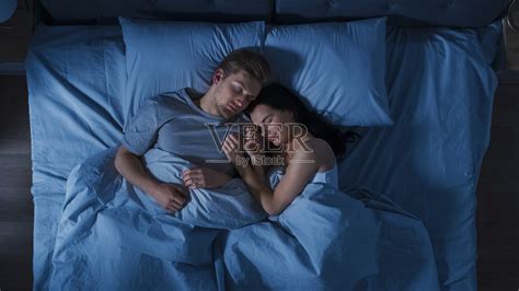 幸福的年轻夫妇拥抱在床上睡觉在晚上。美女和帅哥睡在一起，甜蜜地拥抱在一起。自顶向下。照片摄影图片 Id 340512852 Veer图库