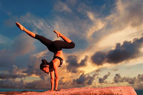 strong woman doing balancing yoga pose outdoors