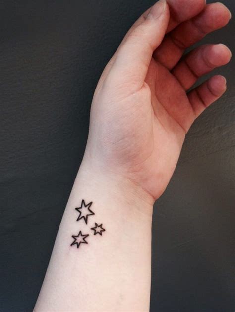 A Womans Wrist With Three Stars On It