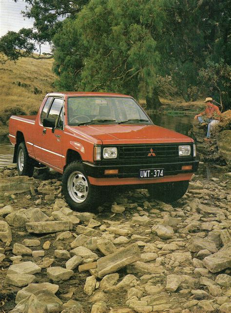 A Red Pick Up Truck Parked On Top Of A Rock Covered River Bank Next To
