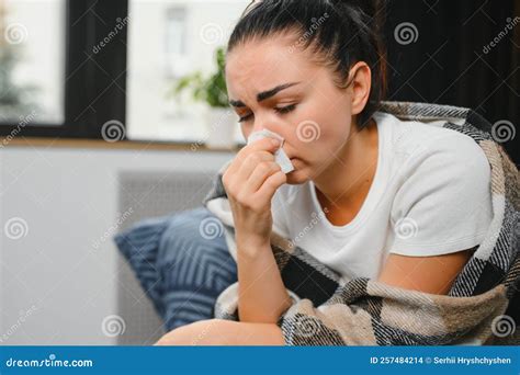Ill Young Woman Sit On Sofa Covered With Blanket Freezing Blowing Her