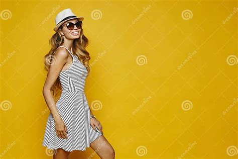 cheerful and smiling blonde model girl with perfect body in white striped fitting dress hat