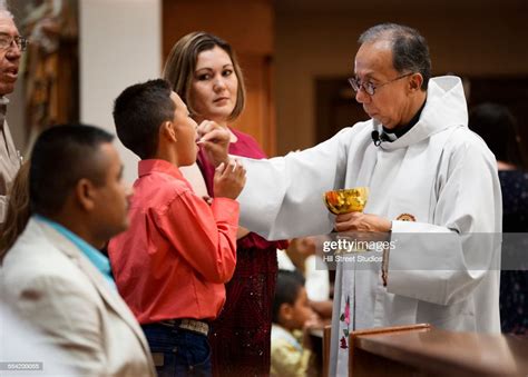 Priest Giving Communion During Mass In Catholic Church High Res Stock