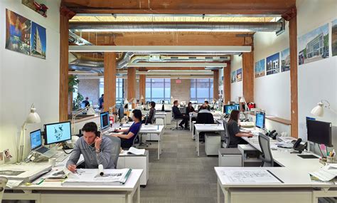 An Office Filled With People Working At Desks