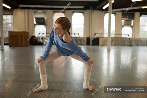 Ballet Dancer Warming Up In Dance Studio — Hands On Knees Stretching