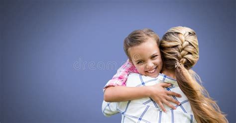 Madre Que Abraza A La Hija Con El Fondo Azul Imagen De Archivo Imagen