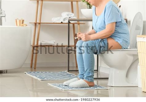 Elderly Woman Hemorrhoids Sitting On Toilet Stock Photo