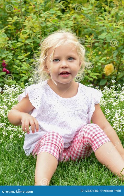 Cute Little Girl Sitting In The Grass In The Garden Stock Image Image