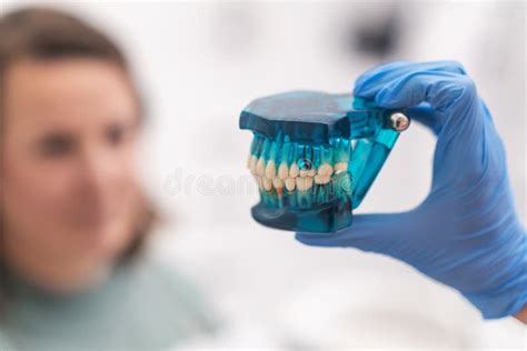 Dentist And Patient Discussing Treatment Plan Looking At A Dental Teeth
