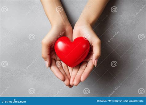 Two Hands Tenderly Holding a Vibrant Red Heart, Symbolizing the