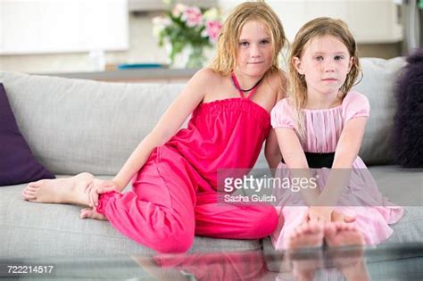 Portrait Of Two Young Sisters Sitting On Sofa Photo Getty Images