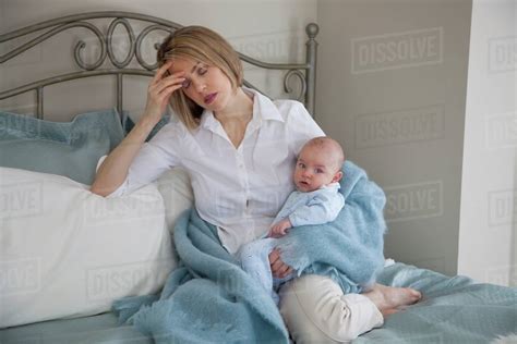 Tired Mom In Bed With A Baby Jordan Ontario Canada Stock Photo