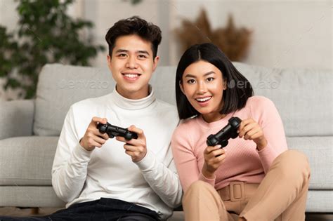 Joyful Asian Boyfriend And Girlfriend Playing Video Game At Home Stock