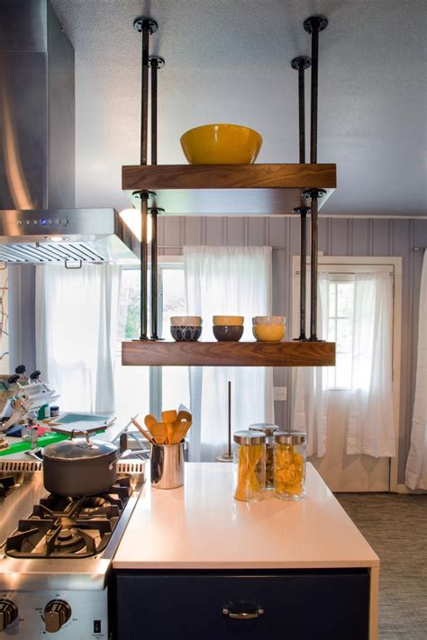 To make the most of your open shelving and to add visual height to your kitchen, stack shelves high, varying shelf height according to what will be stored. Wood shelves suspended from ceiling using plumbing parts ...