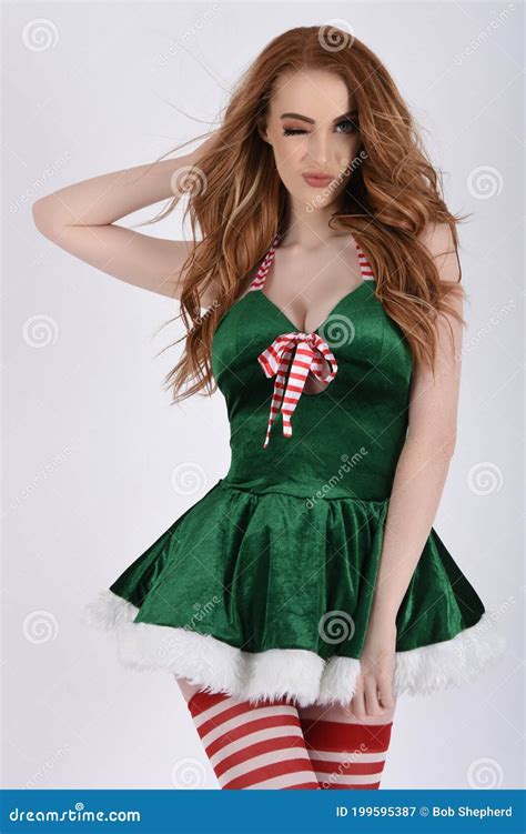 Beautiful Tall Slim Busty Redhead Model Dressed As A Santa Elf And Helpers Stock Image