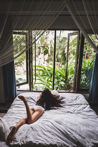 Woman In White Lingerie Lounging In Bed In The Morning View From Window