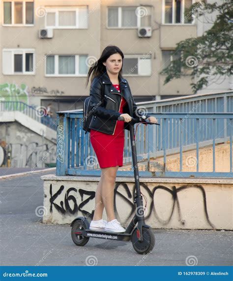 One Teenage Girl Riding An Electric Scooter On City Street Sidewalk Editorial Stock Image