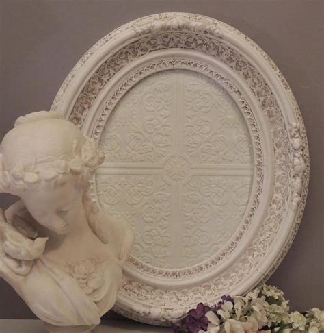 There Is A White Plate With A Statue Next To It And Flowers On The Table