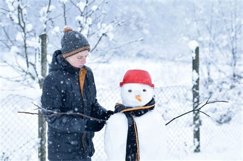 Premium Photo Boy Making A Snowman Fun Winter Activities
