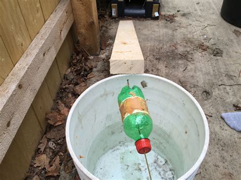 A Green And Red Bottle In A White Bucket