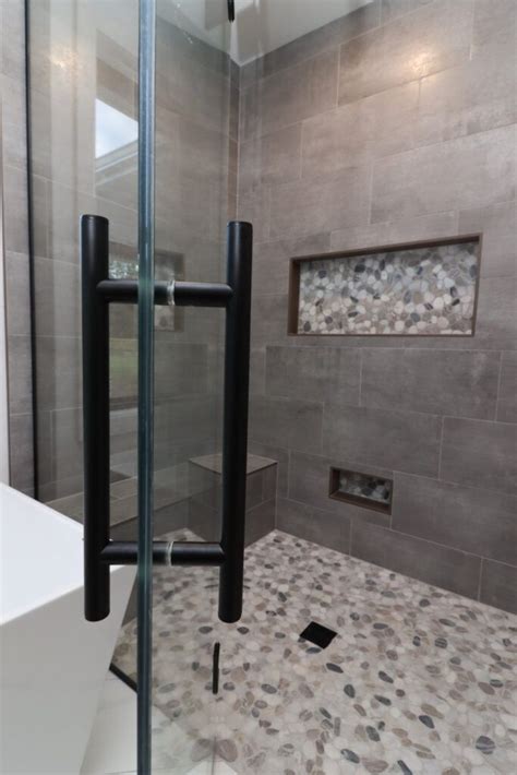 Gray Tile Shower With Light Pebble Flooring Glass Shower Door With
