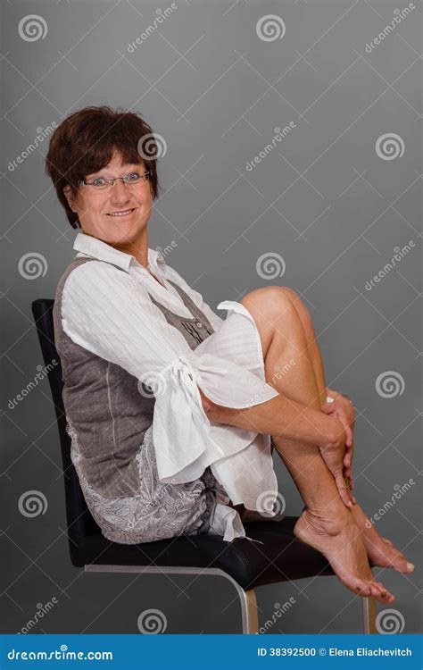 Funny Mature Woman On Chair Barefoot Stock Photo Image
