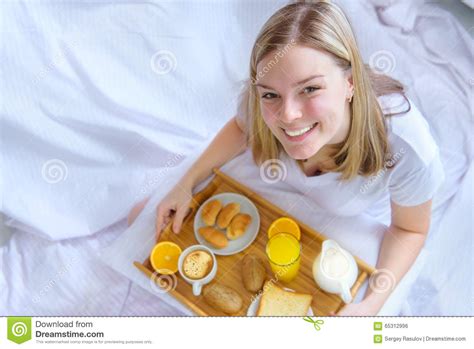 Mujer Que Come El Desayuno En Cama Foto De Archivo Imagen De Resto
