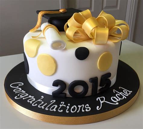 A Decorated Graduation Cake With Yellow And Black Decorations On Its