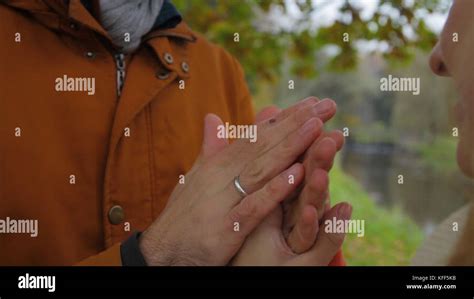 A Man Warms Womans Hands Bride And Groom Holding Hands And Warm Each Other In A Park Man And