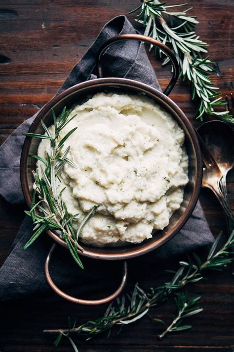 Mashed Potatoes In A Bowl With Rosemary Sprigs On The Side And A Spoon