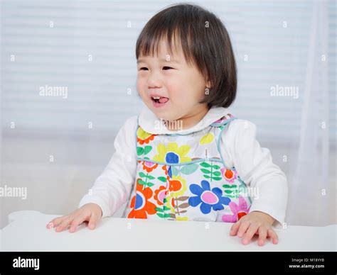 Smiling Baby Girl Sitting On Chair At Home Stock Photo Alamy